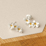 Silver flower earrings styled in product display