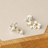 Silver flower earrings styled in product display