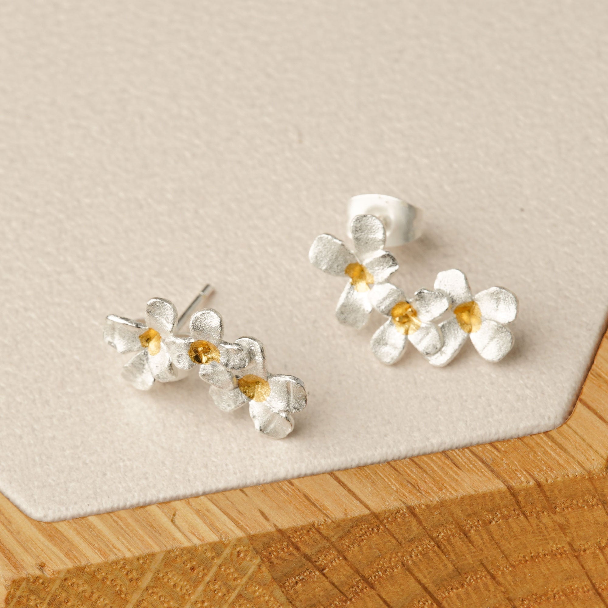 Silver flower earrings styled in product display