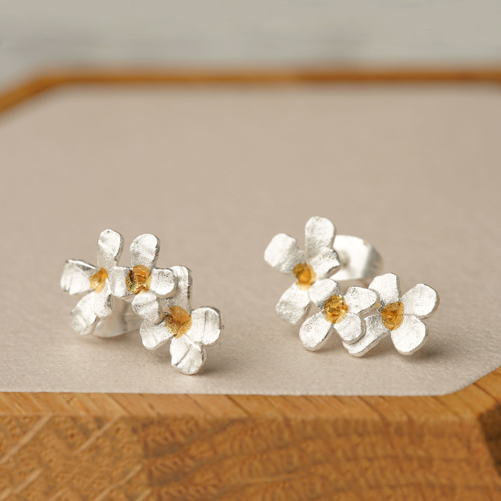 Side view of silver flower earrings with floral shape