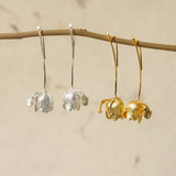Gold and silver tulip earrings hanging side by side, showing contrast between the two finishes